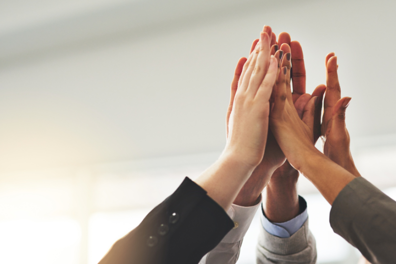 Group of people doing high five.